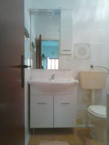 W łazience znajduje się umywalka, toaleta i lustro. w obiekcie Apartments with a parking space Maslenica, Novigrad - 11089 w mieście Maslenica