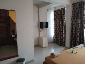 una camera con due letti e una tv di Malhar palace hotel a Shirdi
