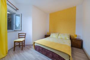 1 dormitorio con 1 cama, 1 silla y 1 ventana en Apartments by the sea Brist, Makarska - 11078 en Brist