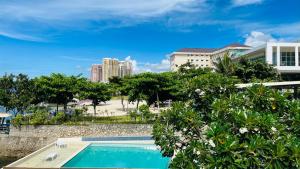 a swimming pool with trees and buildings in the background at Lola's Guest House in Mactan