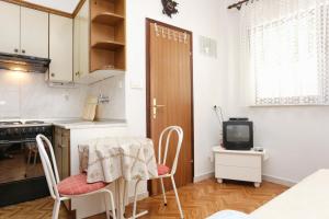 羅戈茲尼察的住宿－Studio Razanj 10373a，厨房配有桌椅和电视。