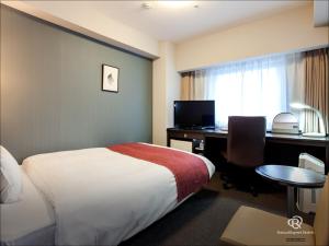 a hotel room with a bed and a desk at Daiwa Roynet Hotel Mito in Mito