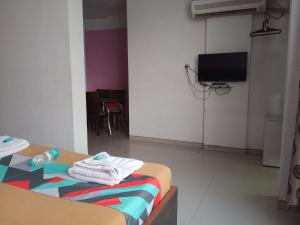 Habitación con cama y TV. en Malhar palace hotel, en Shirdi