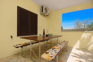 a table and bench in a room with a window at Holiday house with a parking space Kasic, Sibenik - 11079 in Pirovac
