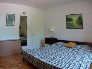 a bedroom with a bed with a blue and white checked blanket at Apartments with a parking space Biograd na Moru, Biograd - 11150 in Biograd na Moru