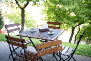a wooden table with two chairs and two cups on it at Hotel Panoramic in Râmnicu Vâlcea