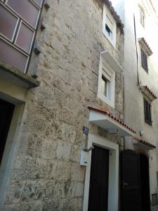 um edifício de pedra com uma porta e uma porta em Seaside holiday house Kastel Stafilic, Kastela - 11165 em Kaštela