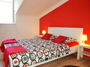 een slaapkamer met een bed met rode muren bij Apartments by the sea Opatija - 11185 in Opatija