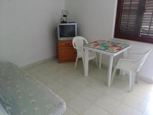 a room with a table and chairs and a tv at Apartments by the sea Hodilje, Peljesac - 11189 in Ston