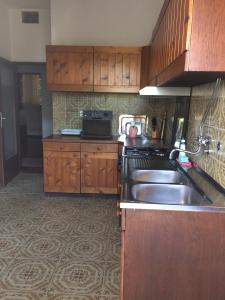 a kitchen with wooden cabinets and a sink at Holiday house with a parking space Valbandon, Fazana - 11172 in Marana