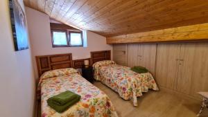 um quarto com 2 camas e um tecto de madeira em Casa rural los 7 pinos de Gredos em Navarredonda de Gredos