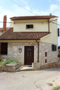 a small stone house with a brown door at Apartments with a parking space Liznjan, Medulin - 11152 in Ližnjan