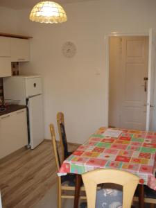 a kitchen with a table and chairs and a kitchen with a clock at Apartments by the sea Krk - 11205 in Krk