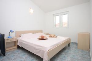 ein Schlafzimmer mit einem Bett mit einem Hut und einem TV in der Unterkunft Family friendly seaside apartments Preko, Ugljan - 8232 in Poljana