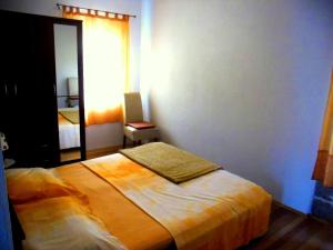 ein Schlafzimmer mit einem Bett in einem Zimmer mit einem Spiegel in der Unterkunft Apartments with a parking space Lukoran (Ugljan) - 11203 in Lukoran