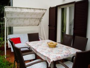 Una mesa y sillas en un patio con una mesa y un dosel. en Seaside holiday house Starigrad, Paklenica - 11240, en Starigrad-Paklenica