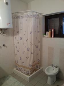 a bathroom with a shower curtain and a toilet at Apartments by the sea Martinscica, Cres - 11279 in Martinšćica
