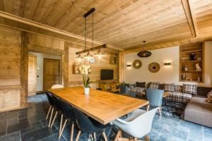 a dining room with a wooden table and chairs at La Grange à Roger in Myans