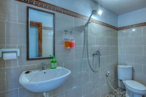 a bathroom with a sink and a toilet and a mirror at Alit Cottage in Nusa Penida