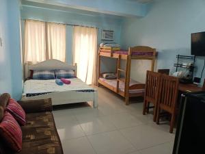 a bedroom with two bunk beds and a desk at Mhavic family room ,group friend good for 6 guest in Manila
