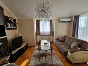 a living room with a couch and a chandelier at Danube duplex apartment in Smederevo