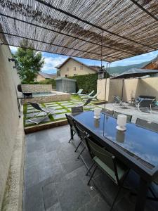 a patio with a blue table and chairs at La Grange à Roger in Myans