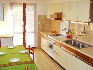 una cucina con tavolo, lavandino e piano cottura di Apartments with a parking space Betina, Murter - 11322 a Betina
