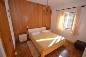 a small bedroom with a bed and a window at Apartments by the sea Splitska, Brac - 11339 in Splitska