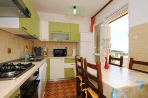 a kitchen with green and white cabinets and a table at Apartments with a parking space Rabac, Labin - 11325 in Rabac +11 photos
