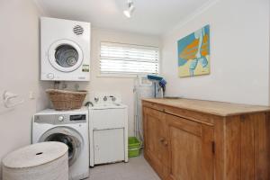a kitchen with a washing machine and a washer at Beach Shack in Hawks Nest