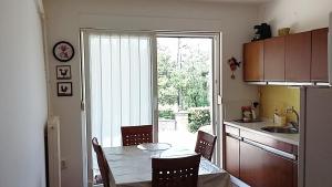 cocina con mesa y cocina con puerta corredera de cristal en Apartments by the sea Klenovica, Novi Vinodolski - 11323, en Klenovica