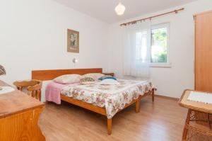 a bedroom with a bed and a table at Apartments with a parking space Mali Losinj (Losinj) - 11344 in Mali Lošinj