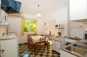 a kitchen with a table and a dining room at Apartments with a parking space Mali Losinj (Losinj) - 11344 in Mali Lošinj