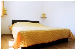 a bedroom with a bed with a yellow bedspread at Apartments by the sea Razanj, Rogoznica - 11347 in Rogoznica