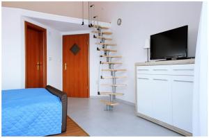 a bedroom with a bed and a tv and a spiral staircase at Apartments by the sea Razanj, Rogoznica - 11347 in Rogoznica