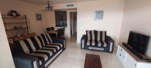 a living room with two chairs and a television at El sol Espanol in Torrox Costa