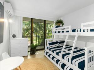 a bedroom with bunk beds and a desk and a table at The Rocks Resort - Official in Gold Coast
