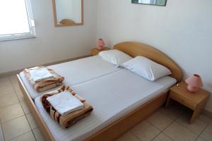 Seaside apartments with a swimming pool Businci, Ciovo - 11232 في تروغير: غرفة نوم عليها سرير وفوط