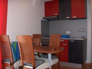 małą kuchnię z drewnianym stołem i krzesłami w obiekcie Apartments with a parking space Jezera, Murter - 11373 w mieście Jezera