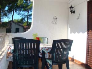 dwa krzesła i stół na patio w obiekcie Apartment Jadrija 11356a w Szybeniku