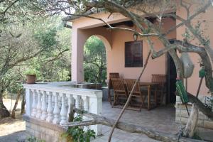 a house with a porch and a table in the yard at Secluded fisherman's cottage Cove Nevidjansko Polje, Pasman - 11392 in Neviđane