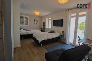 Un dormitorio con dos camas y un televisor y un sofá. en A couper le souffle Magnifique Villa sur l'eau, en La Redonne