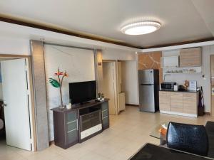 a living room with a television and a kitchen at Condo Minium Patong Phuket in Patong Beach
