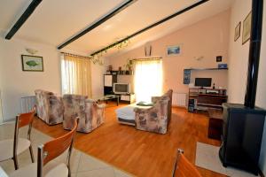 salon z krzesłami i telewizorem z płaskim ekranem w obiekcie Apartments by the sea Suhi Potok, Omis - 11401 w mieście Jesenice