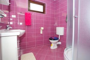 een paarse badkamer met een toilet en een wastafel bij Apartments with a parking space Makarska - 11418 in Makarska
