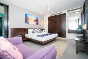 a bedroom with a bed and a purple couch at Karon Sea View Beach Apartment in Karon Beach