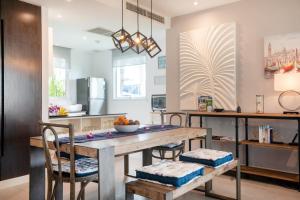 a kitchen and dining room with a wooden table and chairs at Karon Sea View Beach Apartment in Karon Beach