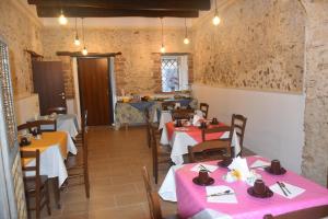 un restaurant avec des tables, des chaises et des tissus de table roses dans l'établissement B&B IlGirasole, à Paravati
