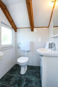 łazienka z toaletą i umywalką w obiekcie Holiday Home Kanica 10367 w Rogoznicy