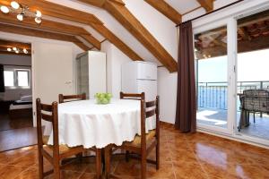 una sala da pranzo con tavolo e sedie bianchi di Holiday Home Kanica 10367 a Rogoznica (Rogosnizza)